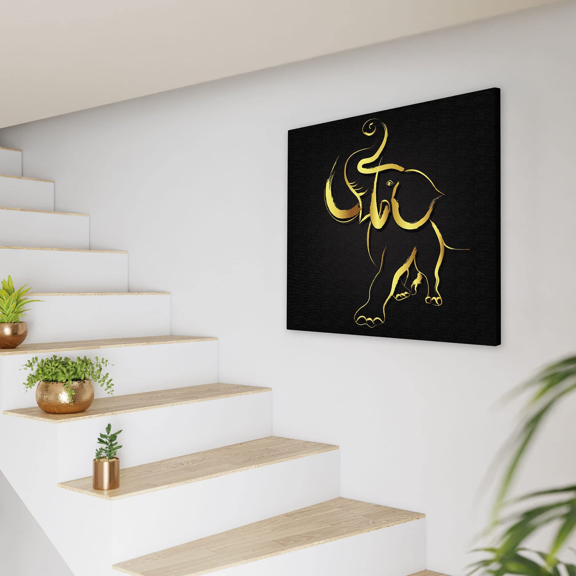 Abstract black and gold elephant art on canvas hanging on white wall near staircase with minimalist decor