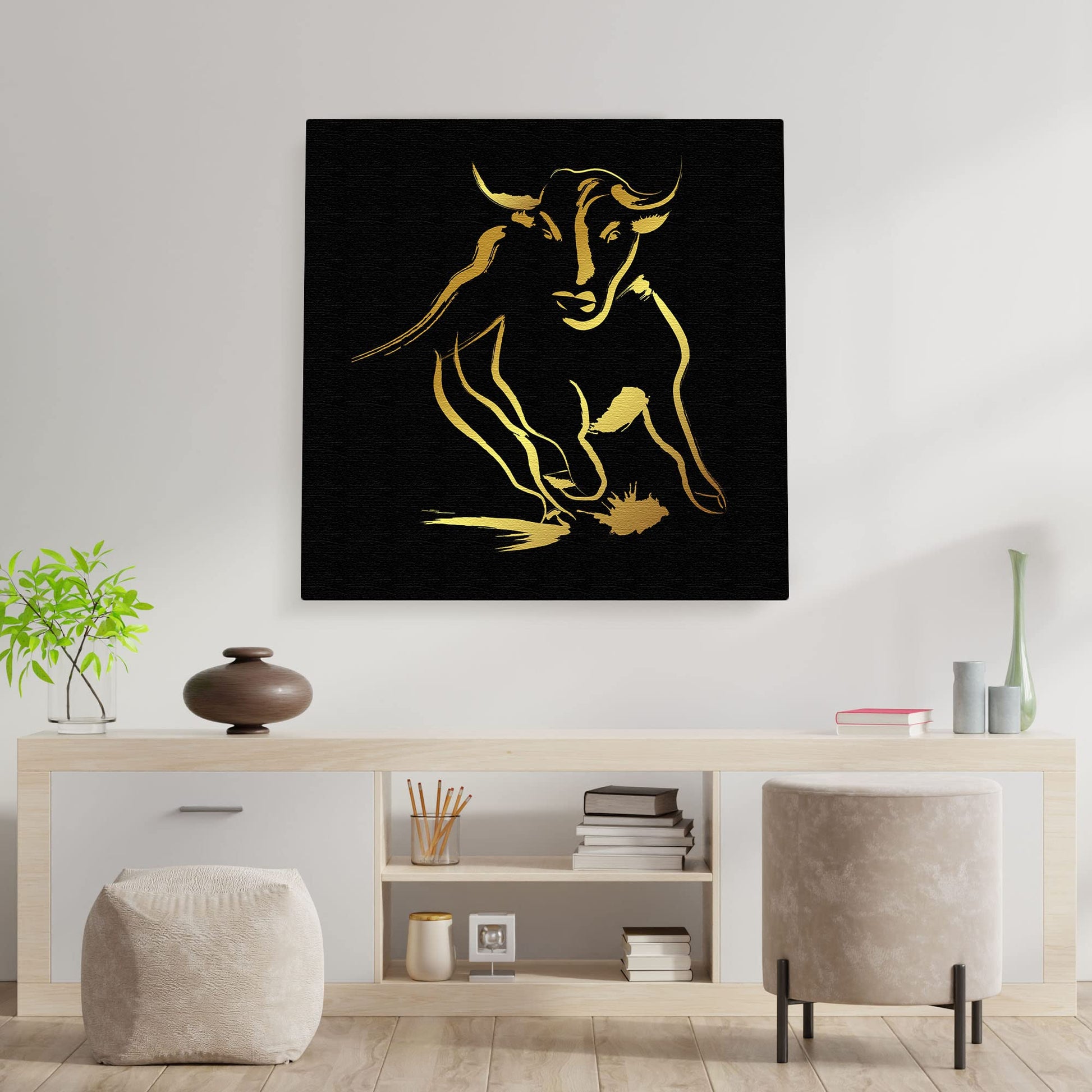 Black and gold abstract bull art with sleek brushstroke design on square canvas above minimalist console table in modern room