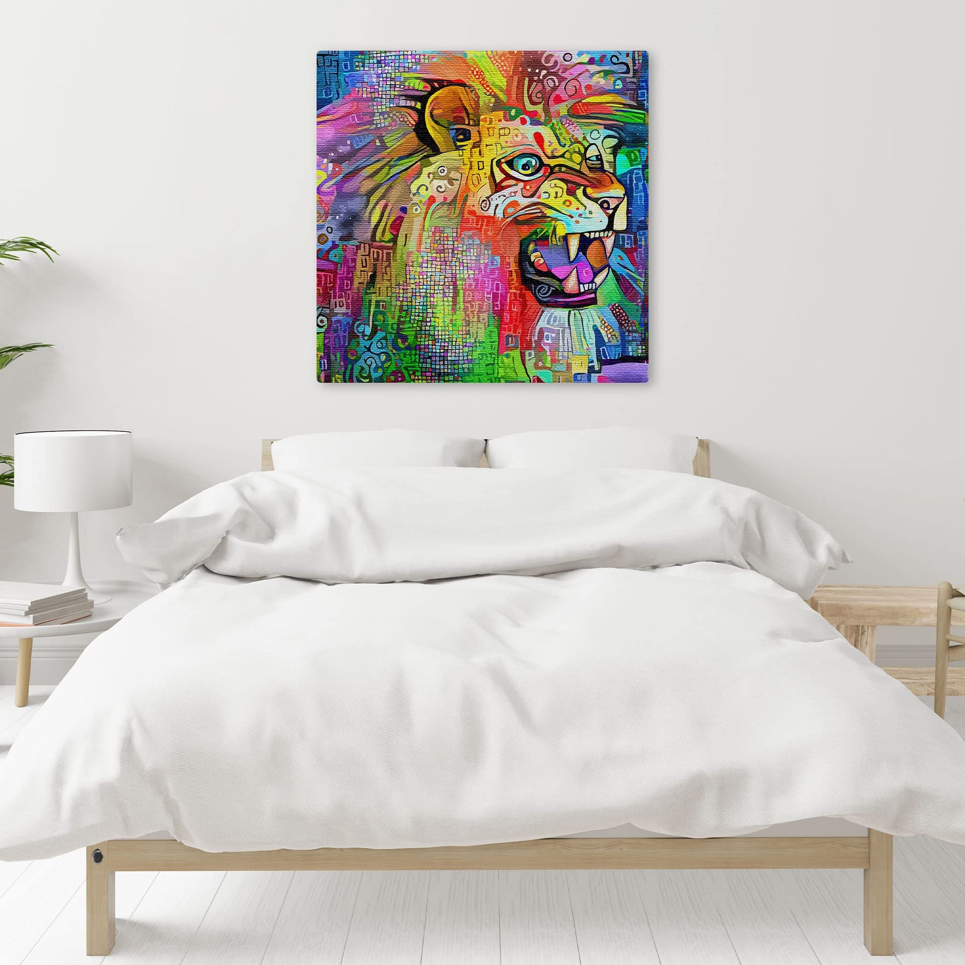 Vibrant multicolored abstract lion artwork on square canvas displayed on white bedroom wall above simple wooden bed