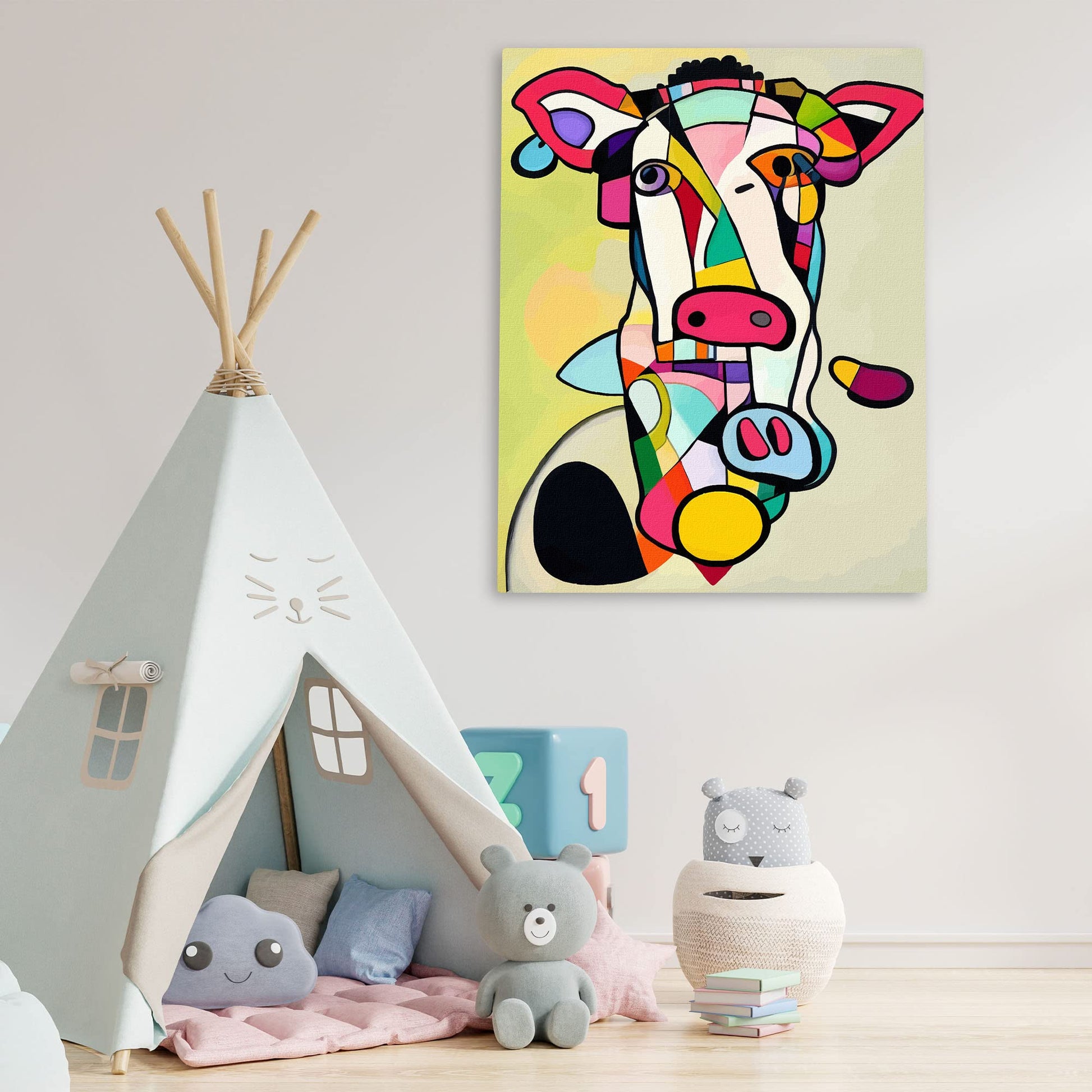 Colorful abstract cow painting with bold geometric shapes on canvas displayed above children's play area with toys and teepee