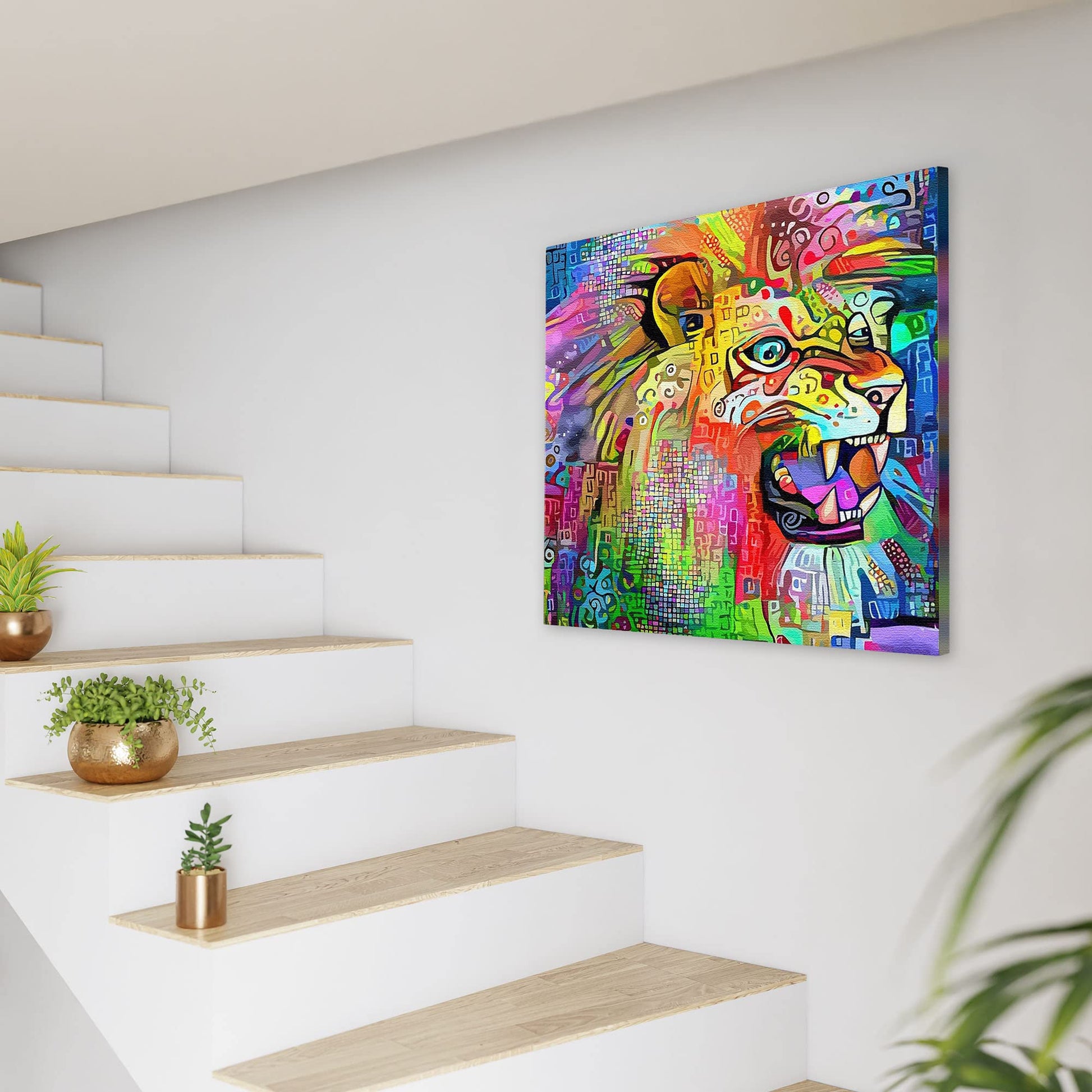Bright multicolored abstract lion artwork on square canvas displayed on white wall beside modern staircase with plants