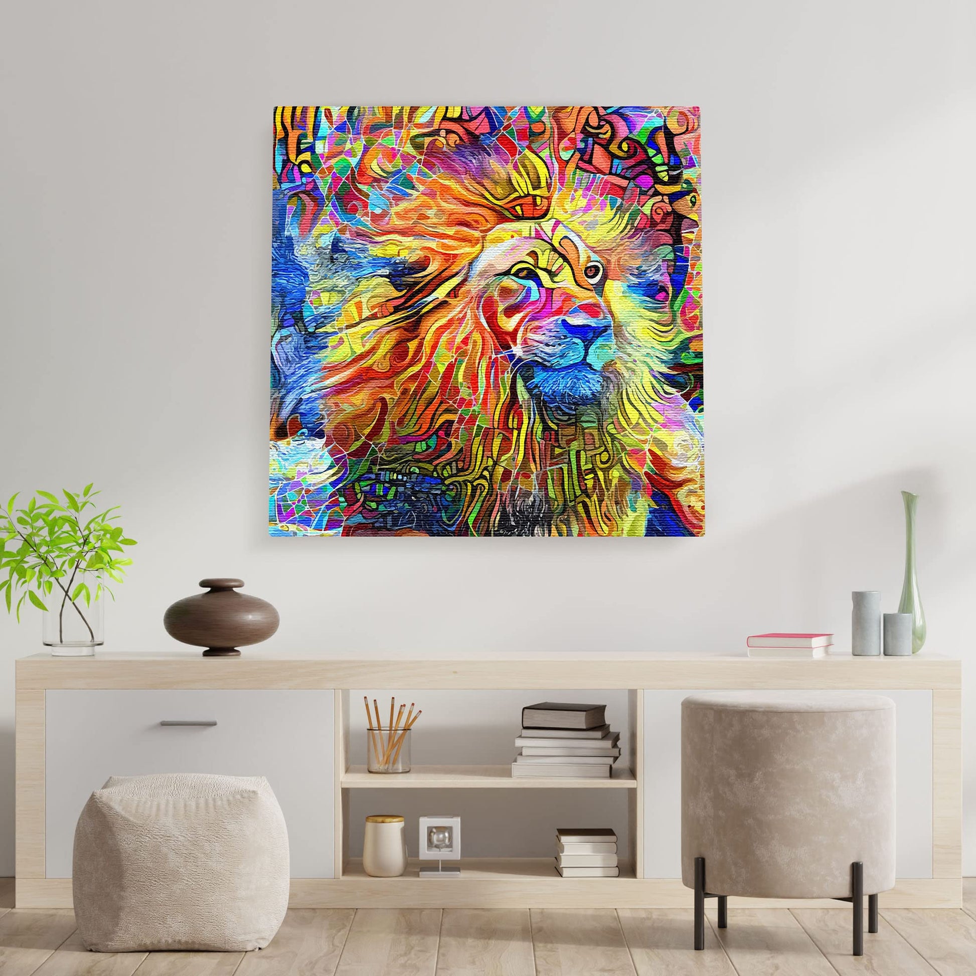 Bright colorful abstract lion artwork on square canvas displayed on white wall above minimalist wooden console with decor items