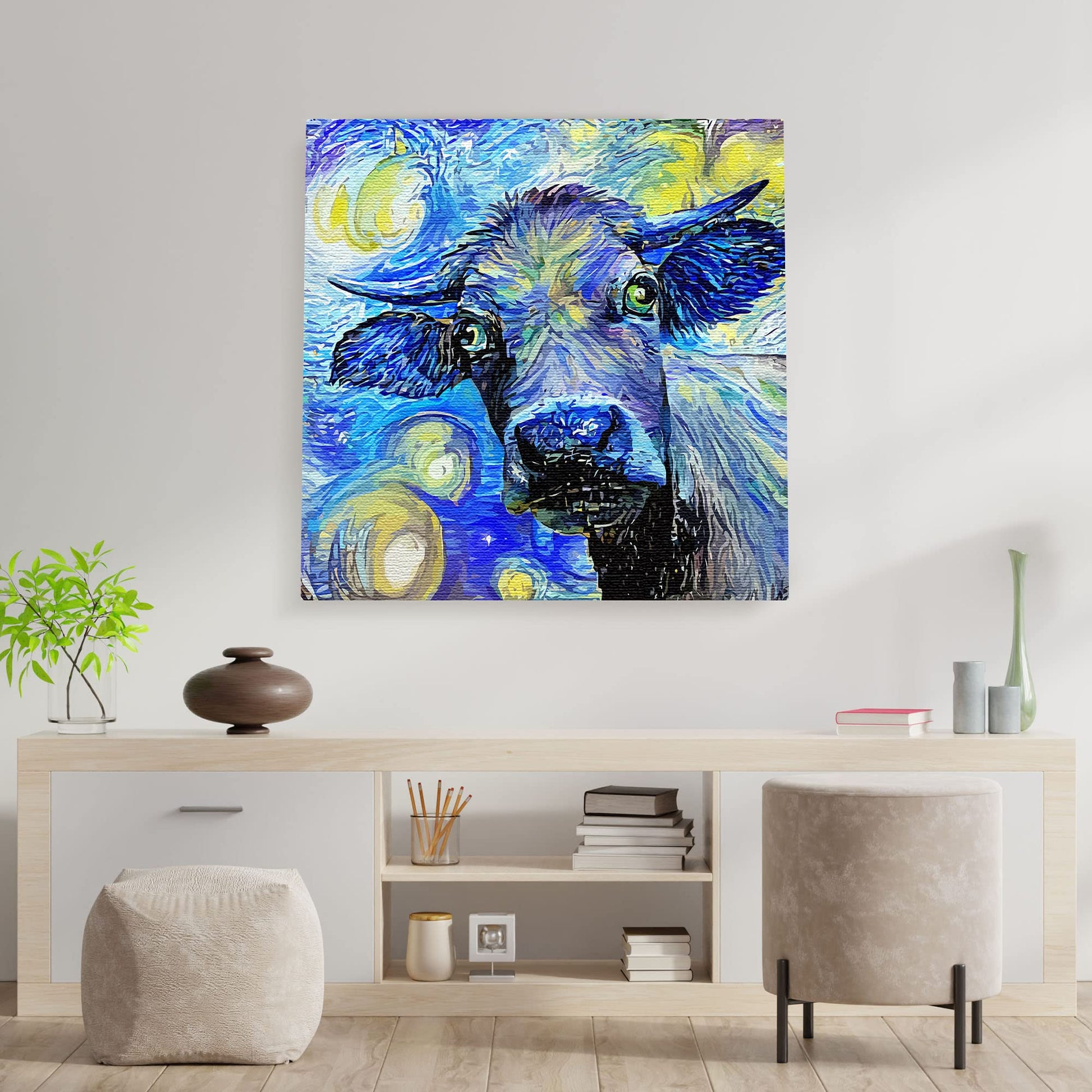 Blue abstract cow art canvas with expressive brushstrokes displayed on white wall above modern console table