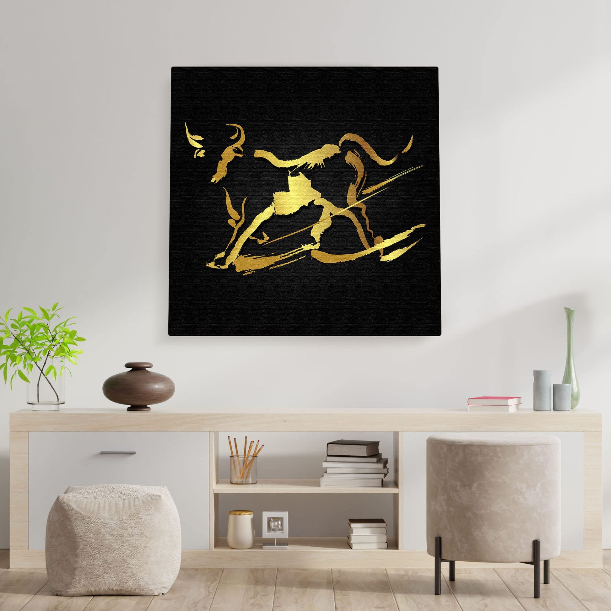 Abstract black and gold bull wall art with bold brushstroke design on square canvas above modern minimalist console table