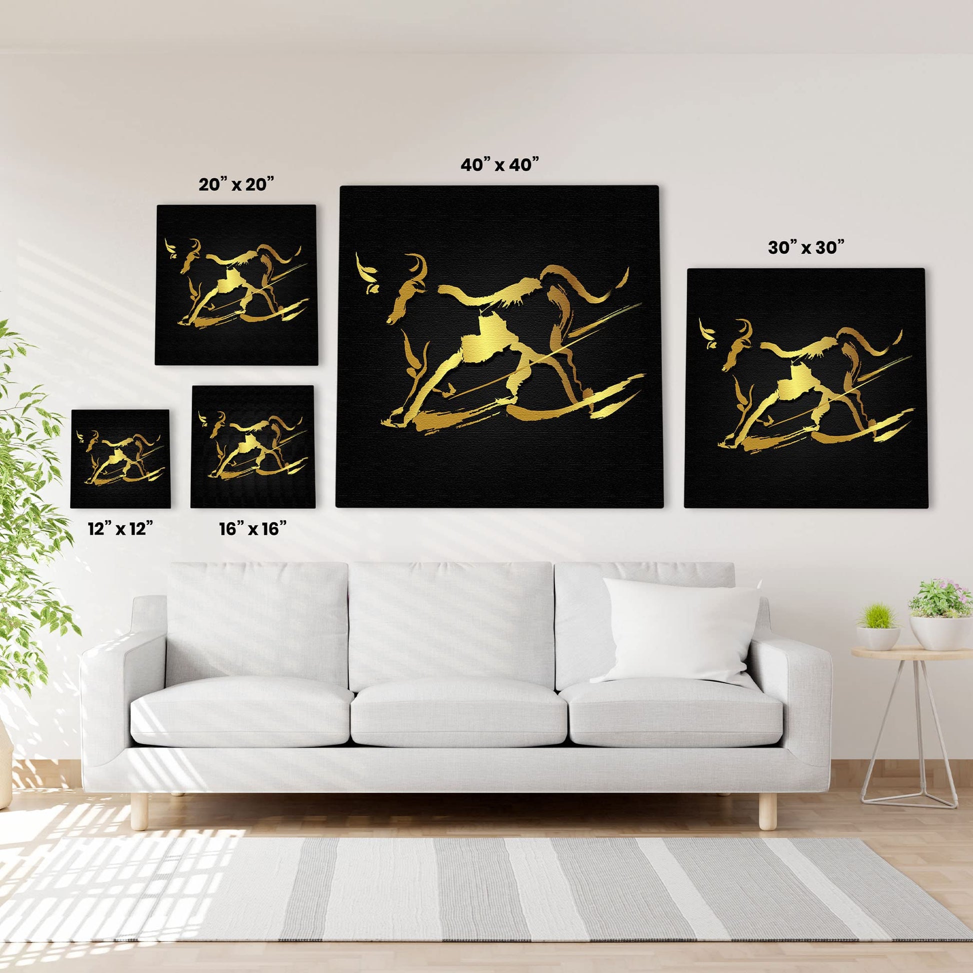 Abstract black and gold bull wall art in five size options displayed above white sofa in modern living room