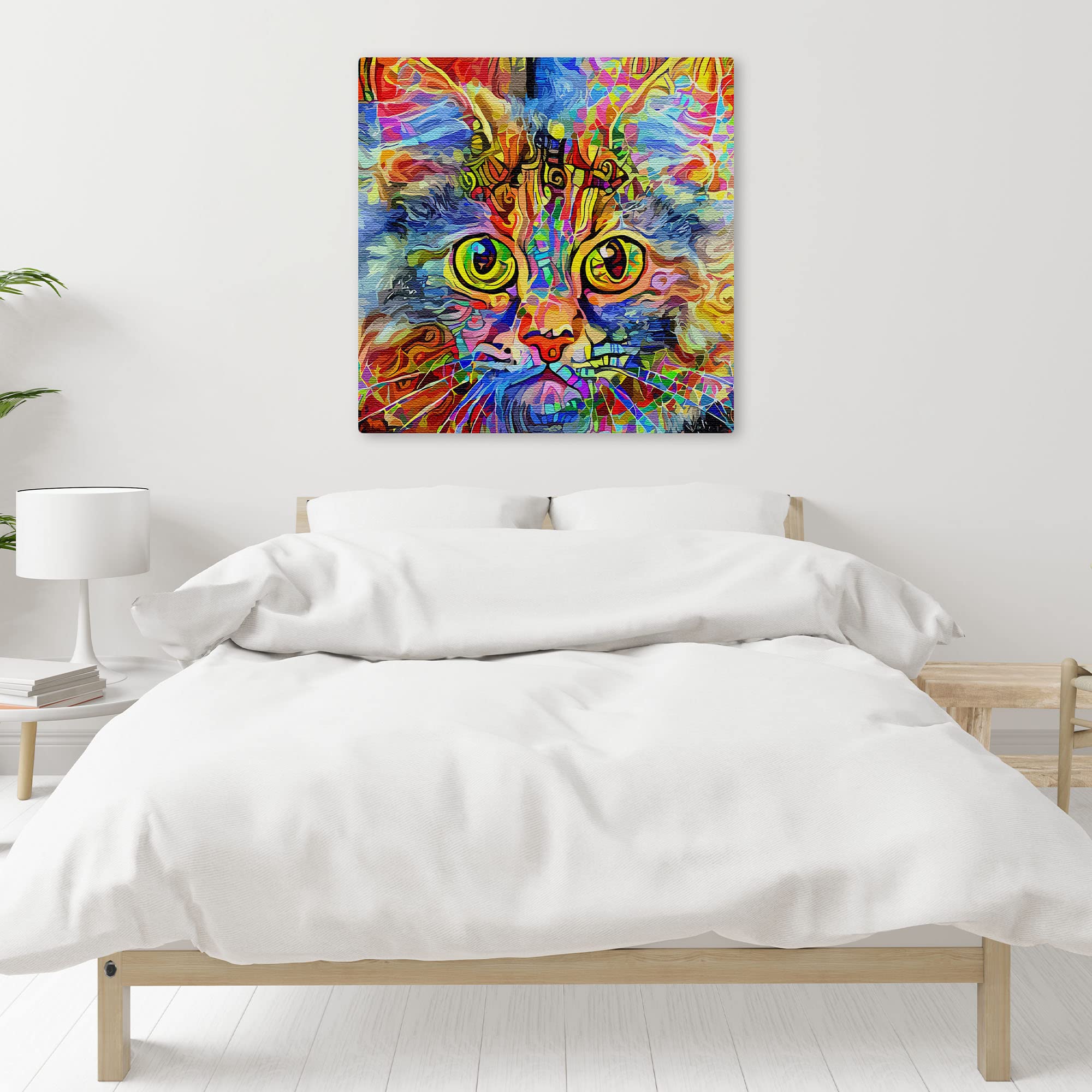 Vibrant cat art canvas with bold multicolor abstract patterns and large expressive green eyes on square canvas above white bed