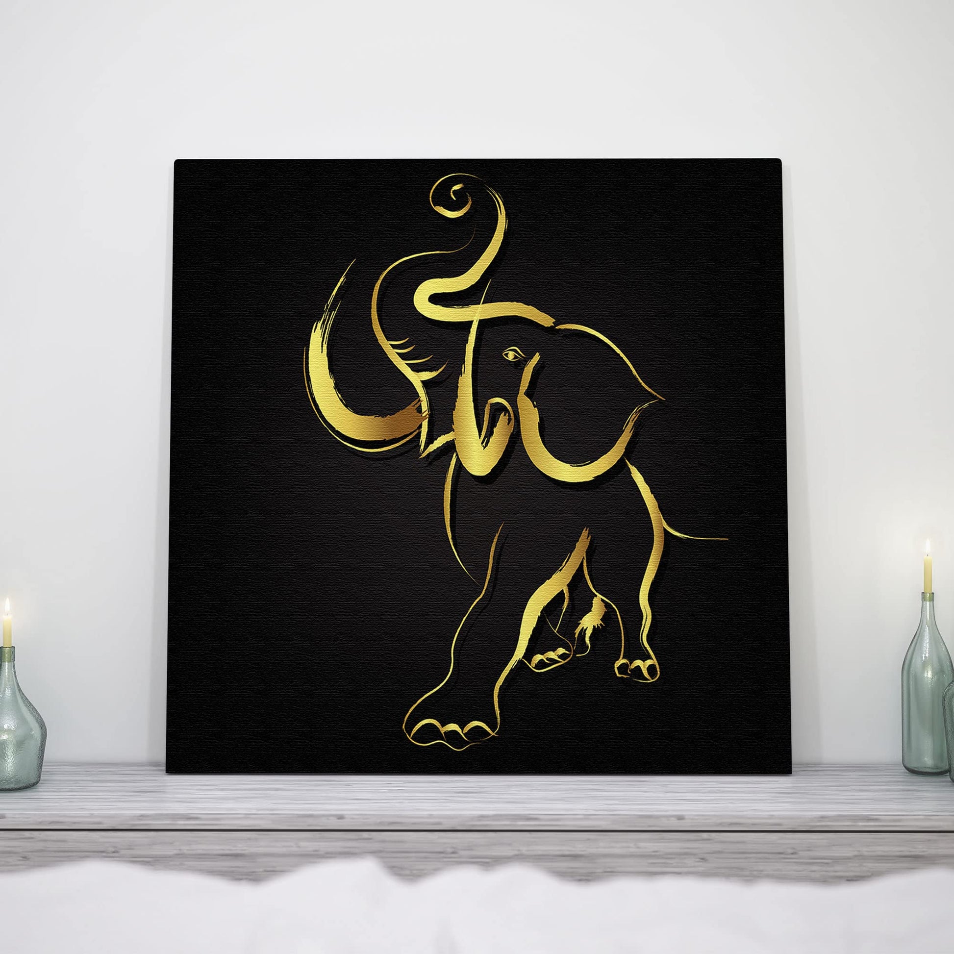 Abstract black and gold elephant art on canvas displayed on white mantel with candles in minimalist decor