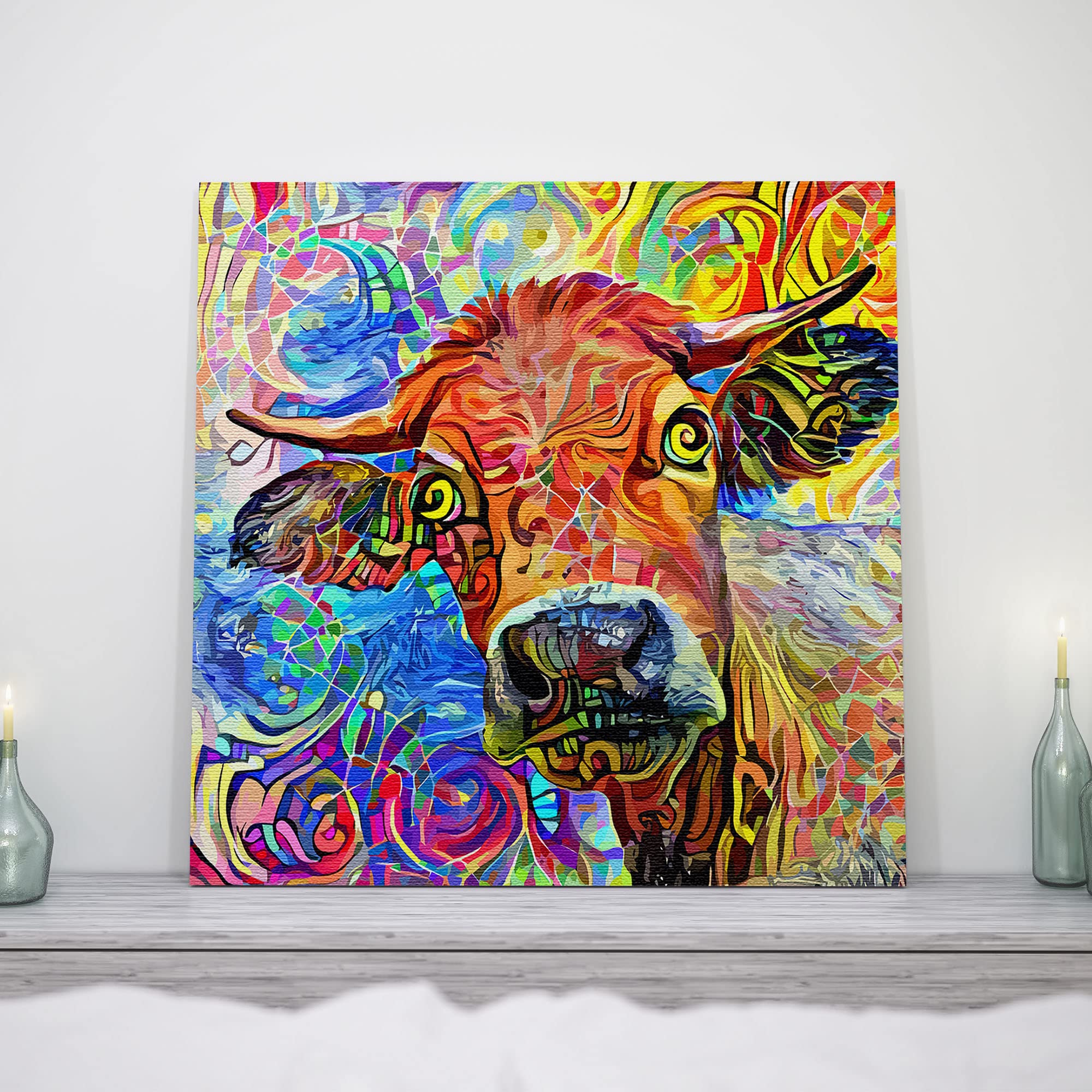 Colorful abstract cow painting with vibrant swirling patterns on square canvas displayed on white wall above mantle with candles